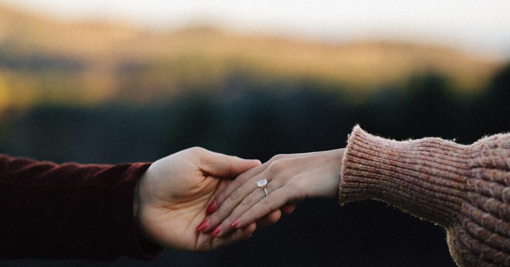 A couple showing an engagement ring, on questions to ask before getting engaged