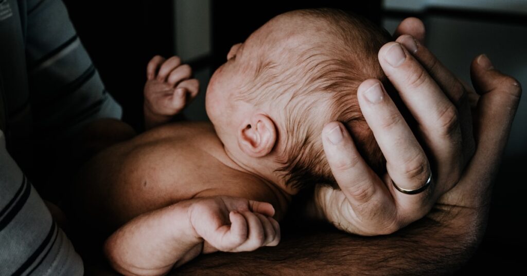 A parent and newborn representing marriage after a baby