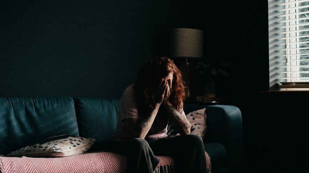A woman sitting alone, carrying the household mental load