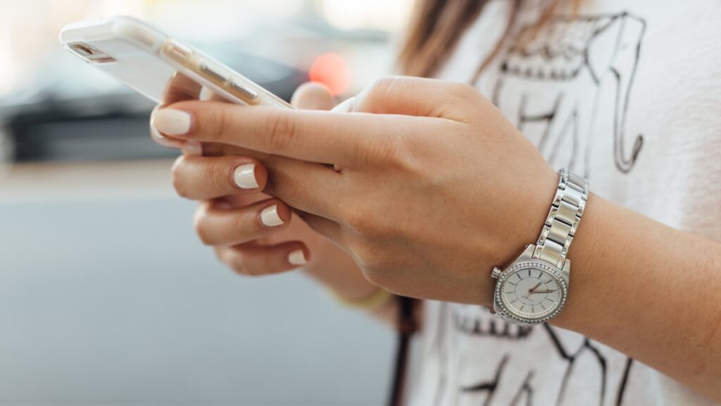 Woman checking her phone for a breadcrumbing text that never becomes a plan