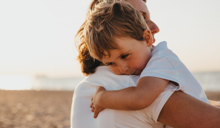 A child hugging a parent, illustrating emotion coaching