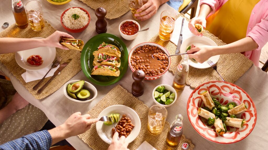 Family gathered around a table sharing a meal, the result of kin-keeping work