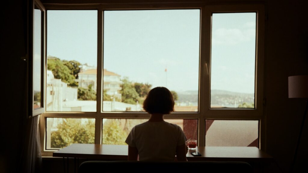 Life after divorce: a person sitting at a table looking out a window in the morning