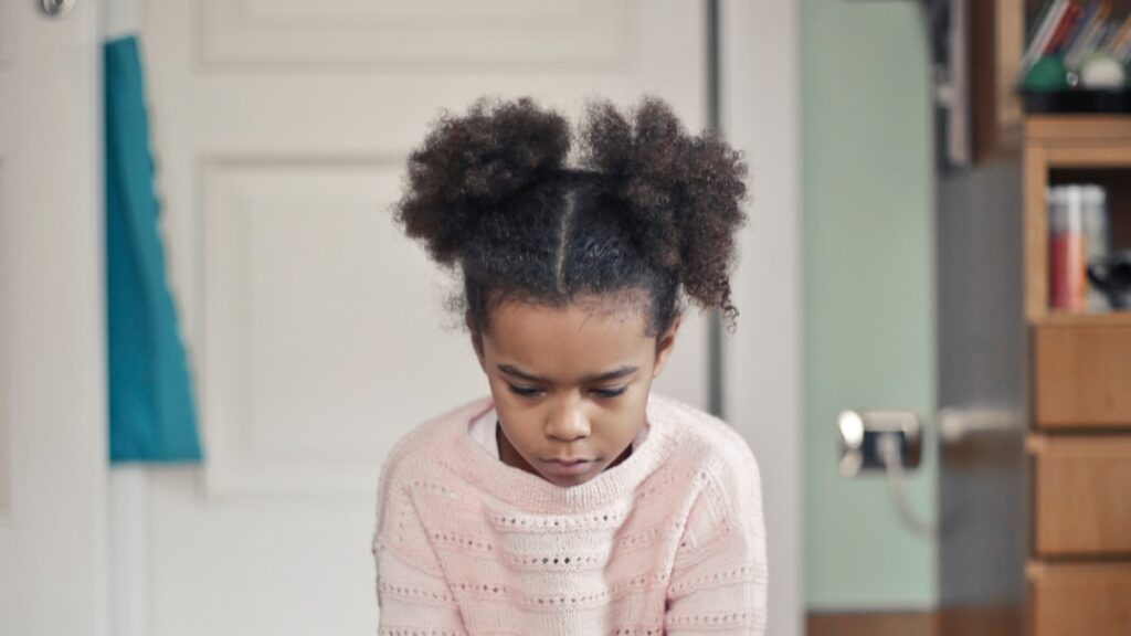 Distracted parenting shown as a parent glancing at a phone near a child