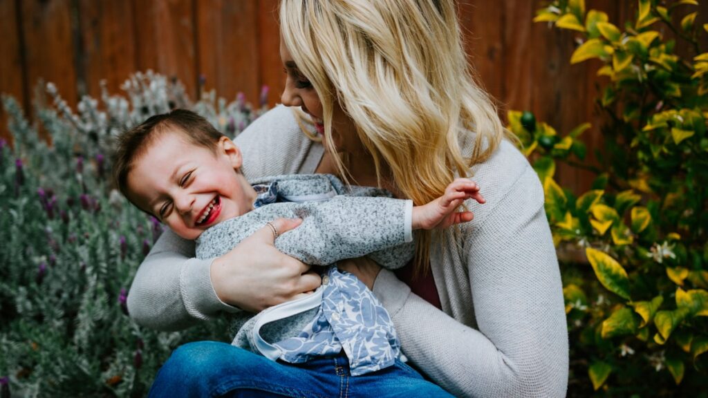 touched out parent: an exhausted mother carrying her child, craving a moment of physical space