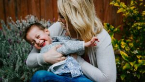 touched out parent: an exhausted mother carrying her child, craving a moment of physical space
