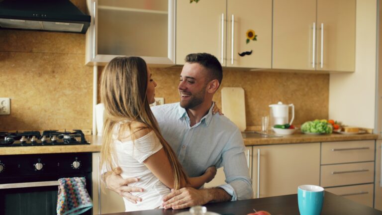 Couple turning toward each other in the kitchen, a bid for connection