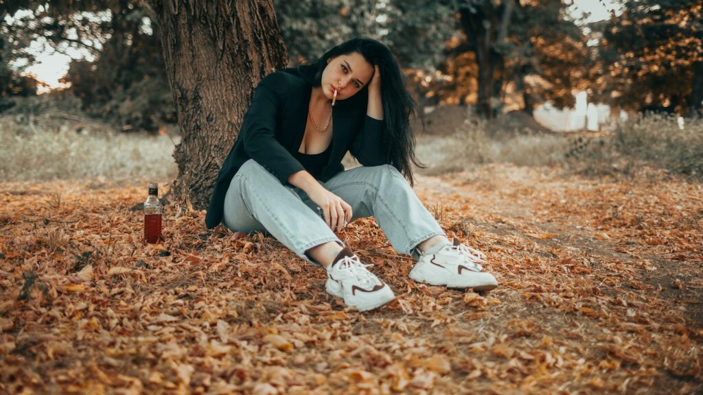 Woman sitting alone under a tree after a breakup
