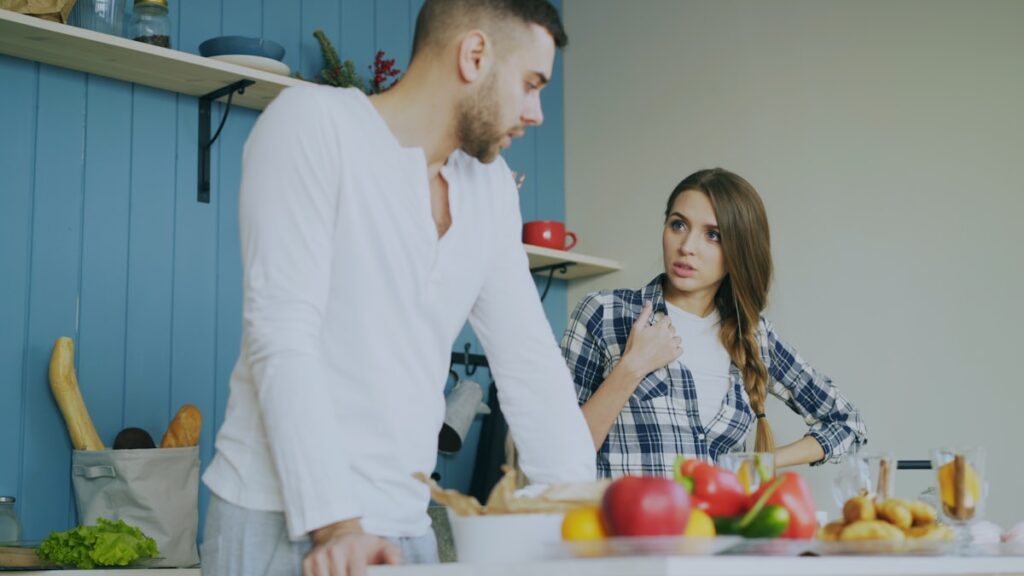 A couple arguing in a kitchen, illustrating defensiveness in marriage