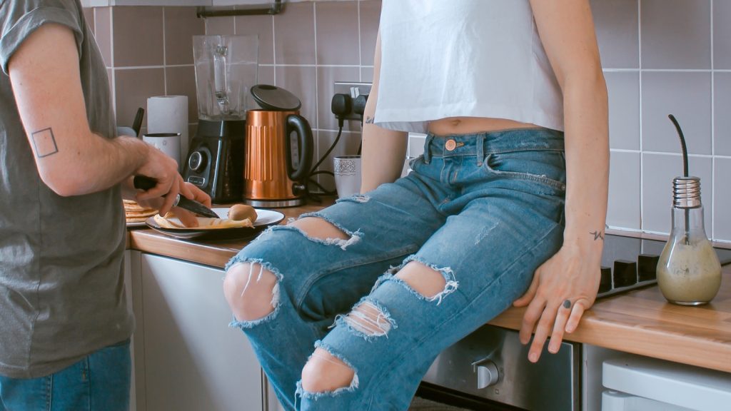 A couple standing together in a kitchen, navigating marriage after job loss