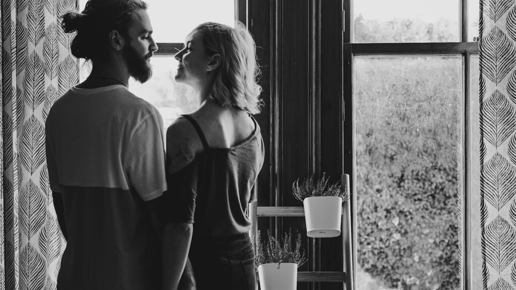 A couple facing each other near a window, illustrating the Michelangelo phenomenon in marriage