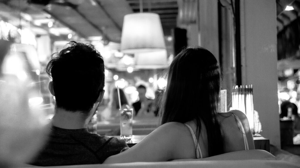 Couple sitting apart, weighing whether to stay in a sunk cost relationship