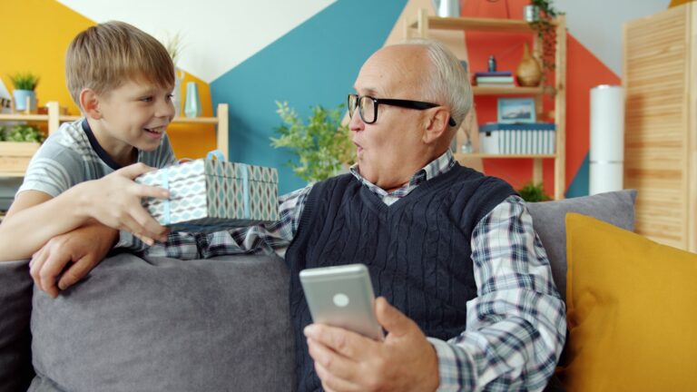 Grandfather receiving a gift from his grandson at home