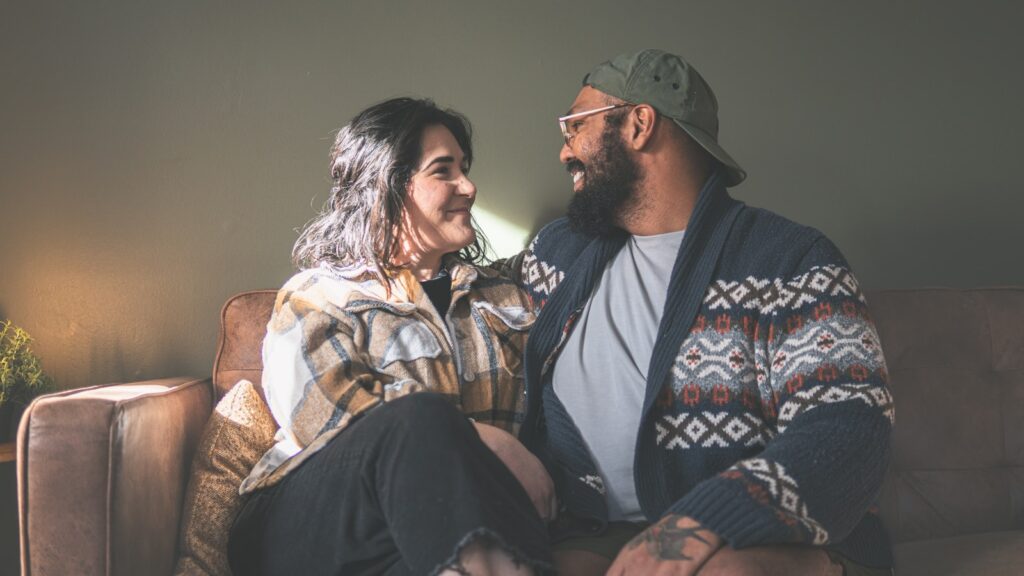 Married couple sitting on a couch discussing money problems