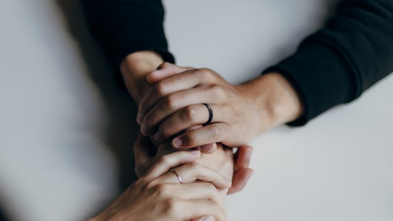 Two partners holding hands, rebuilding an anxious avoidant relationship