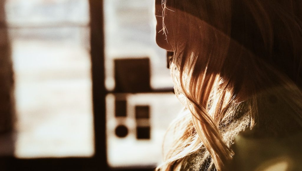 A person standing in a doorway, reflecting the boundary ambiguity that lingers after divorce