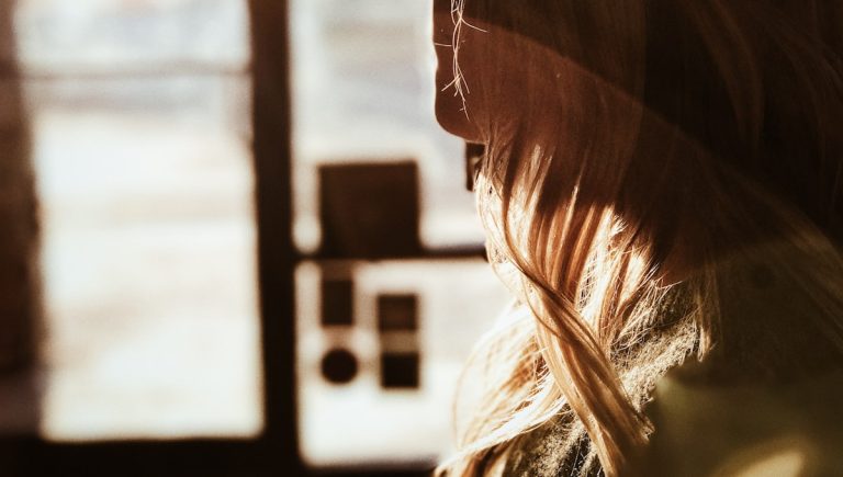 A person standing in a doorway, reflecting the boundary ambiguity that lingers after divorce