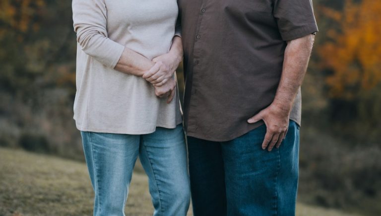 A couple supporting a spouse with chronic illness by facing it together