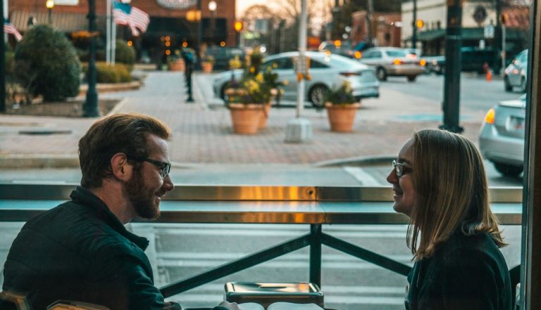 Couple sitting outdoors talking through overfunctioning and underfunctioning in marriage