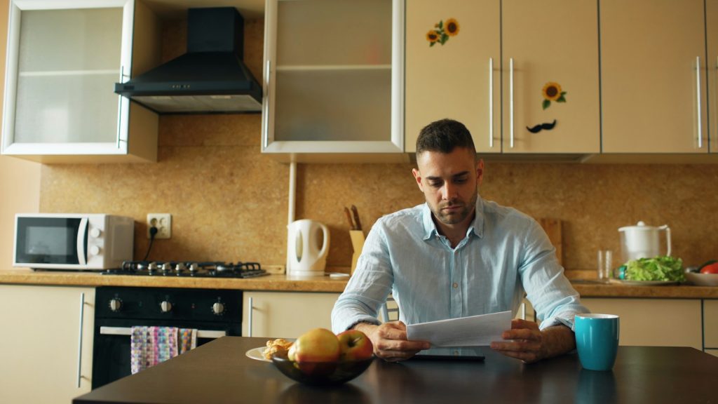 Parent reading paperwork at a kitchen table while learning how child support works