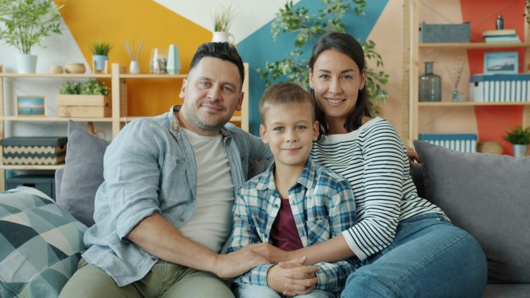 Mother, father and child on a couch as parents who disagree on parenting talk it through