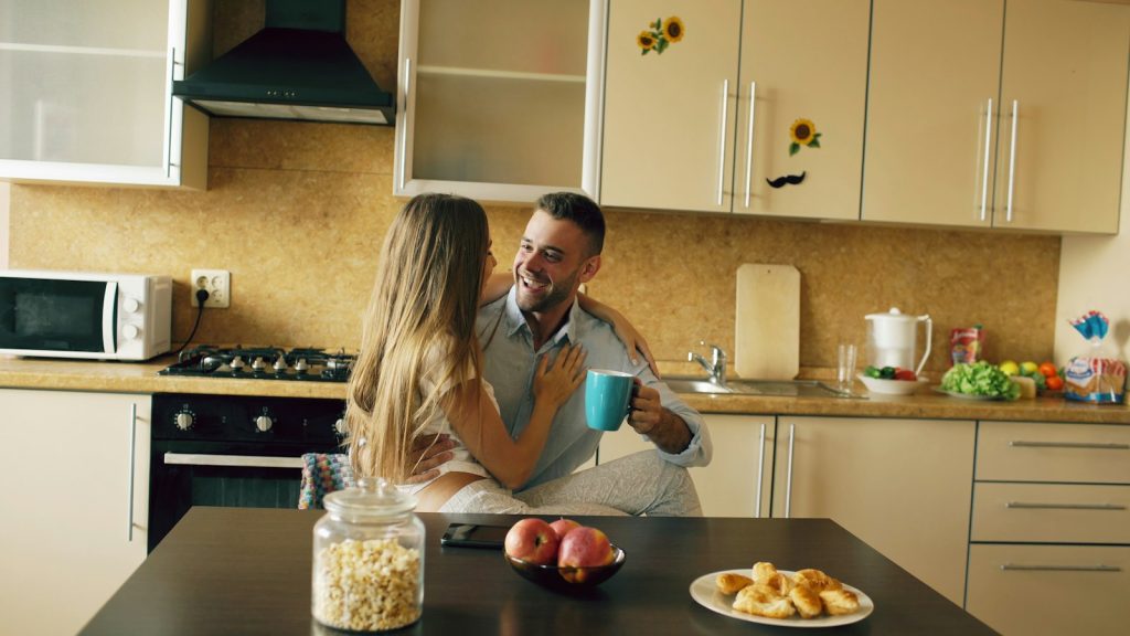 Couple talking over coffee in a bright kitchen during a marriage check-in