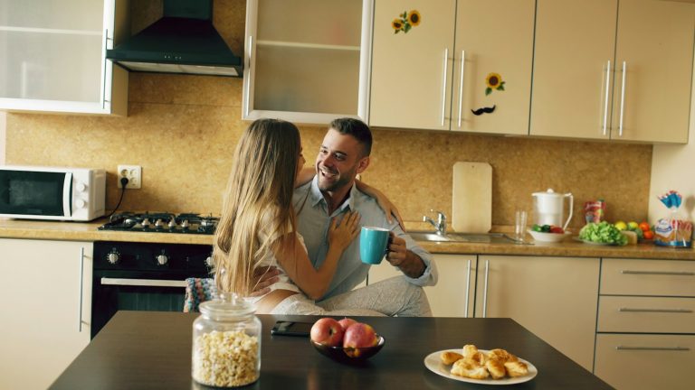 Couple talking over coffee in a bright kitchen during a marriage check-in