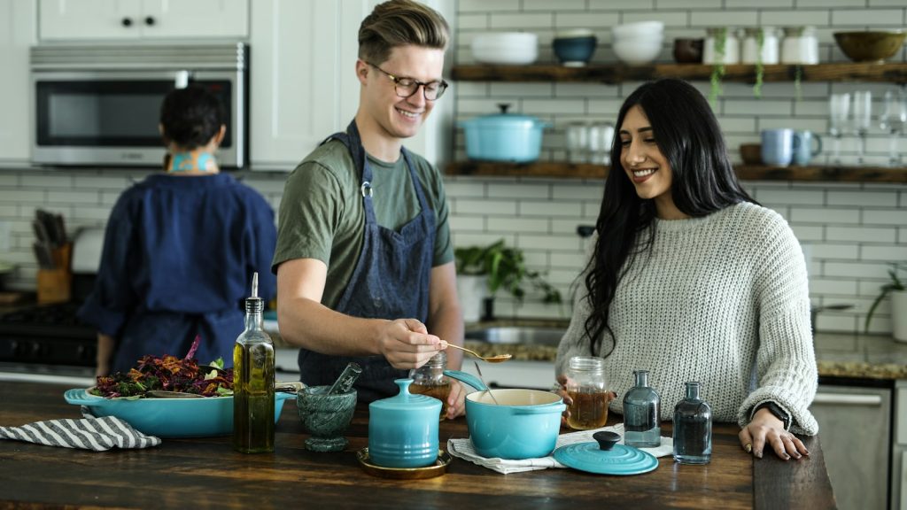 Smiling couple cooking together, sharing traditions in intercultural relationships