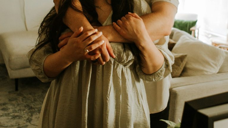 Couple hugging after a sincere apology, showing how to apologize to your spouse well