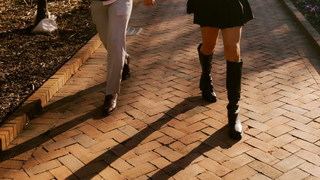 Engaged couple holding hands on a brick path while discussing a prenuptial agreement