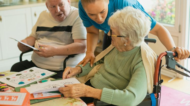 Adult caregiver helping an elderly couple at home, caring for aging parents