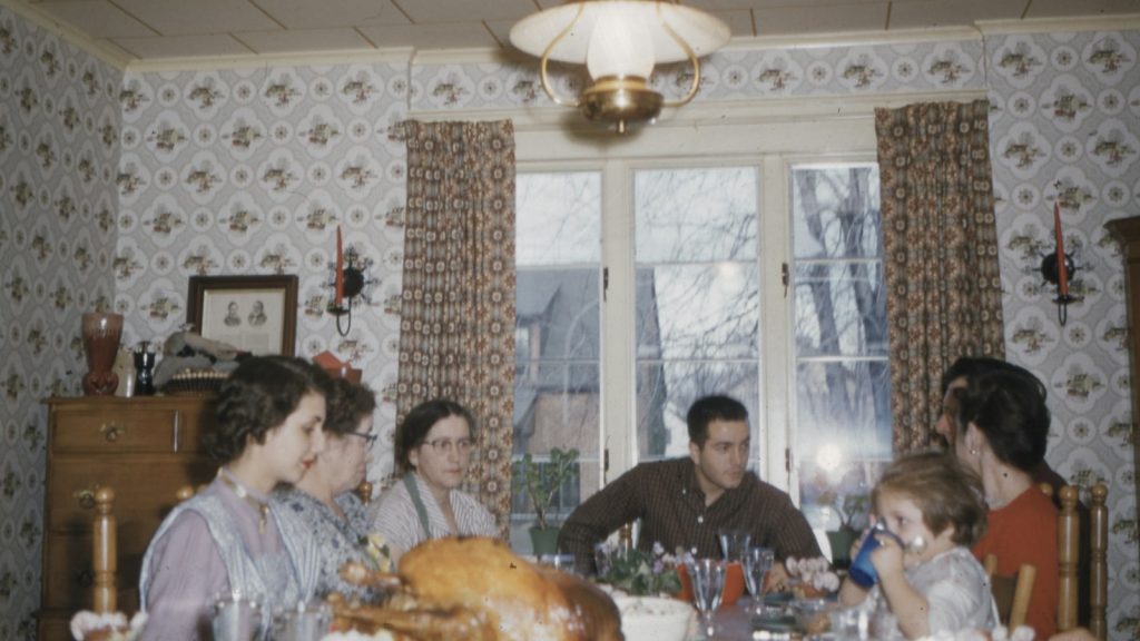 Family sitting around a dining table, planning a co-parenting holiday schedule