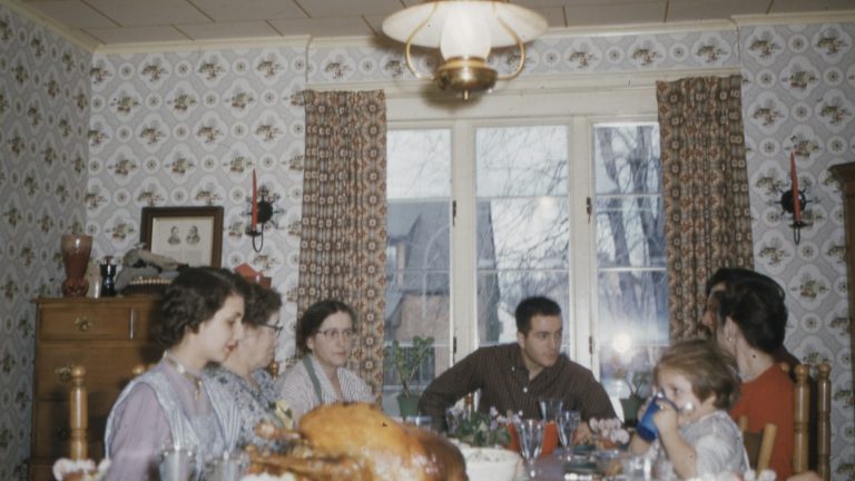 Family sitting around a dining table, planning a co-parenting holiday schedule