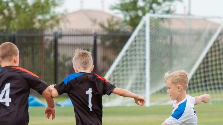 Children playing soccer on grass, enjoying the game without youth sports pressure