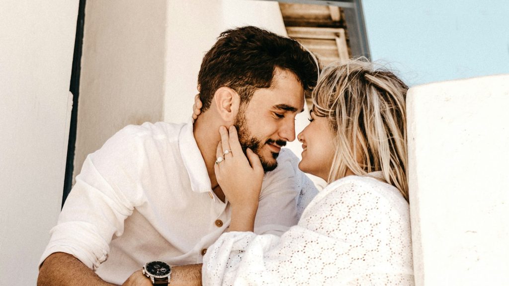 Smiling couple leaning in close during the honeymoon phase of their relationship