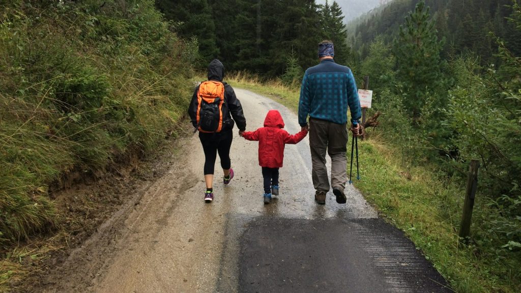 Parents walking hand in hand with their only child