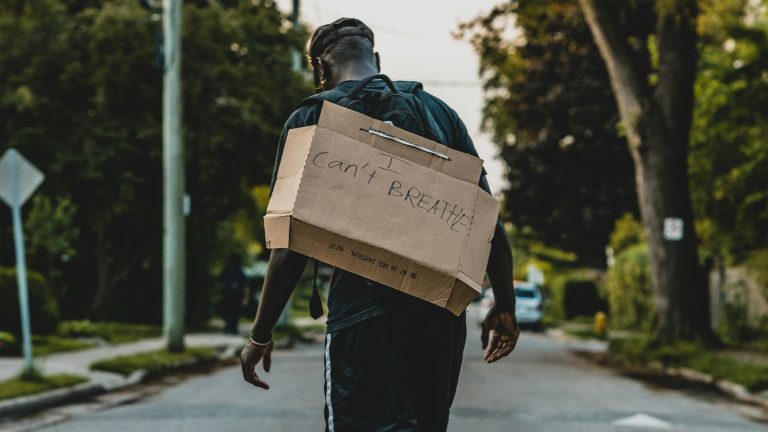 Young man carrying a cardboard box: adult children moving back home often start here
